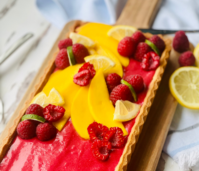 https://mirjamskitchenyodel.com raspberry mango tart with mango and raspberry decoration