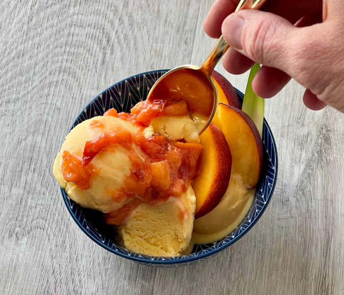 https://mirjamskitchenyodel.com peach ice cream taking a spoon full