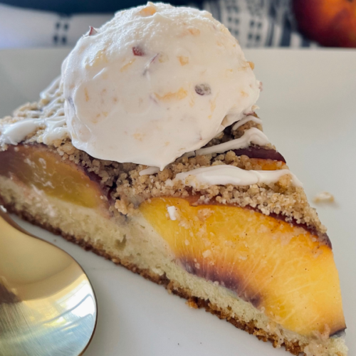 https://mirjamskitchenyodel.com peach crumb coffee cake with peach ice cream on top