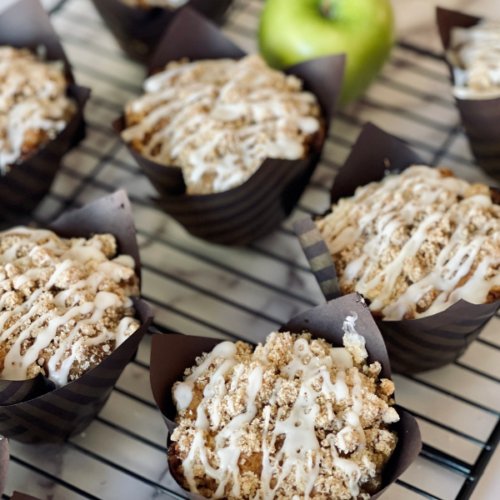 https://mirjamskitchenyodel.com apple cinnamon streusel muffins on rack with apple in the background