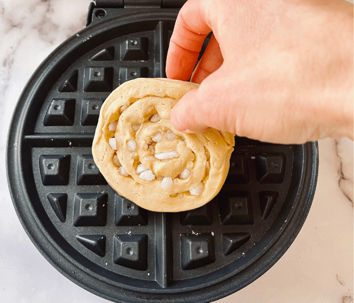 https://mirjamskitchenyodel.com putting a waffle into the waffle iron