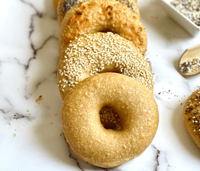 https://mirjamskitchenyodel.com homemade bagels layered in a row