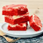 https://mirjamskitchenyodel.com red velvet cheesecake squares stacked on top of each other