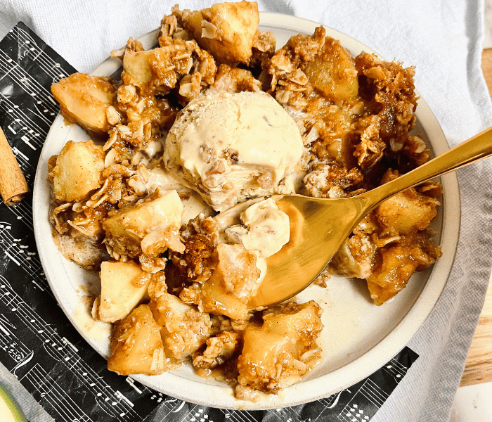 https://mirjamskitchenyodel.com apple cinnamon crisp with ice cream and a spoon
