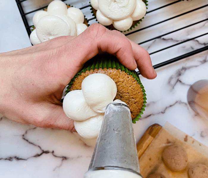 https://mirjamskitchenyodel.com piping baileys swiss meringue buttercream onto cupcakes