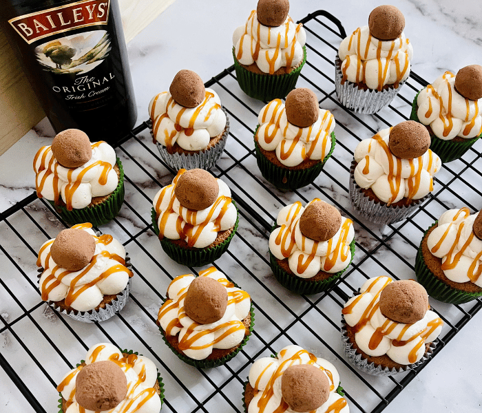 https://mirjamskitchenyodel.com chocolate baileys cupcakes on cooling rack with baileys bottle in the background